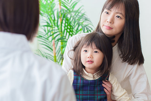 診察を受ける女の子小児科医とお母さん